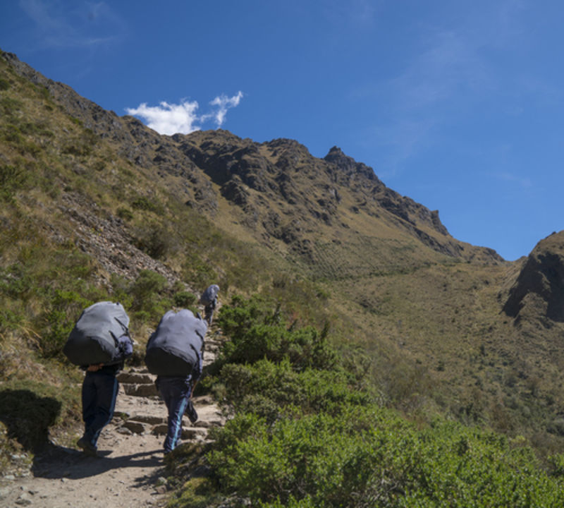 Three porters walking up to Dead Woman-s Pass on Inca Trail 