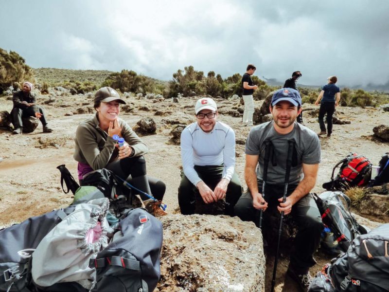 Trekkers taking a rest and sitting on rocks on Kilimanjaro