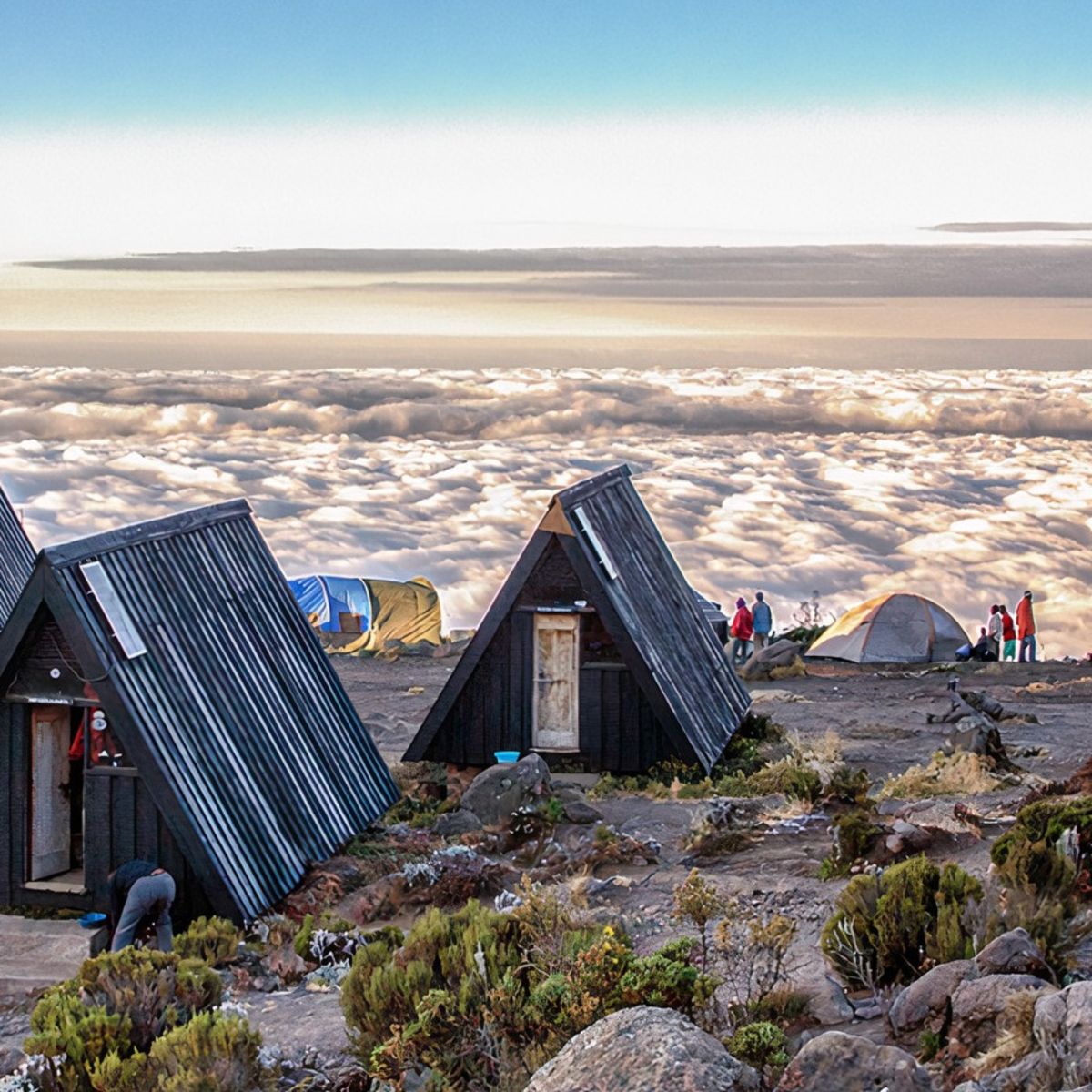 A-frame huts at MArangu route campsite with blanket of cloud below