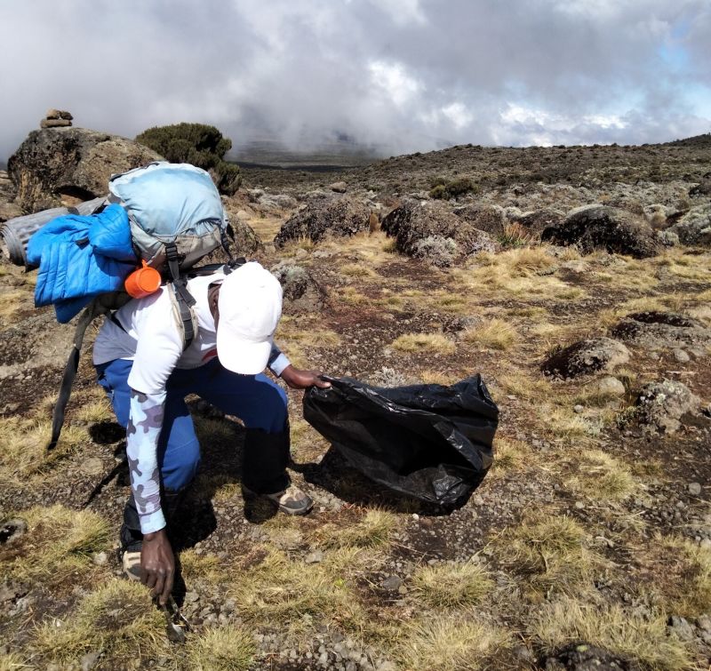 Follow Alice team member picking up litter on Kilimanjaro