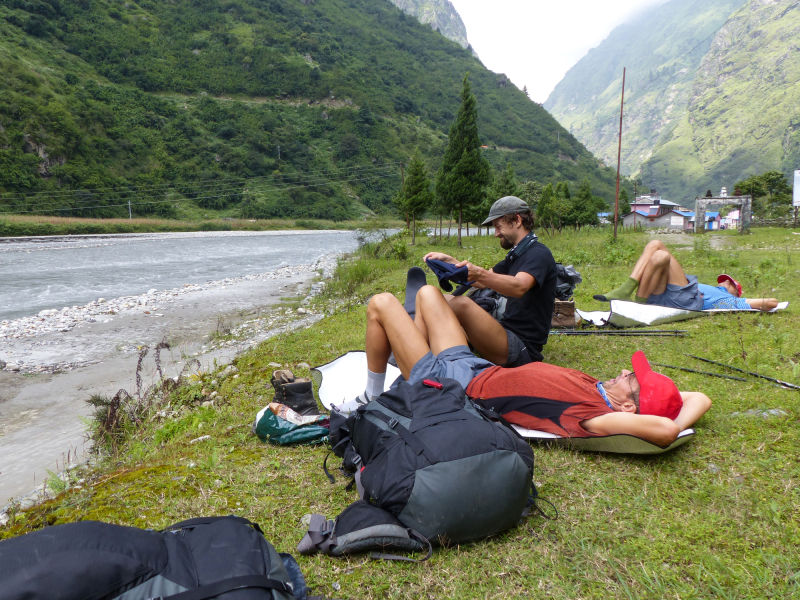 Trekkers resting by river on Annpurna Circuit, Nepal