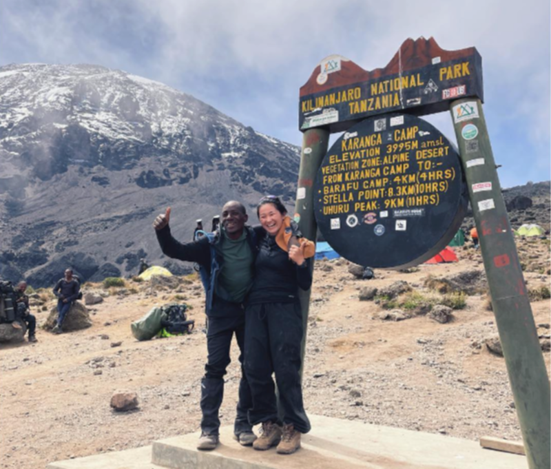Female and male hikers standing by sign for Karanga Camp on Kilimanjaro, August 2022