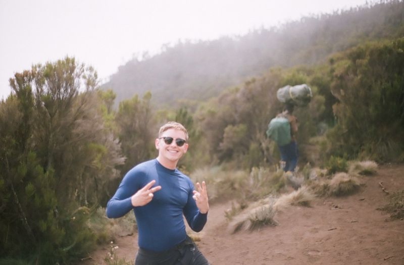 Male hiker smiling at camera standing in moorland of Kilimanjaro