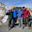 Trekkers smiling in front of Thorung La stone and prayer flags on Thorung La pass on the Annapurna Circuit in Nepal