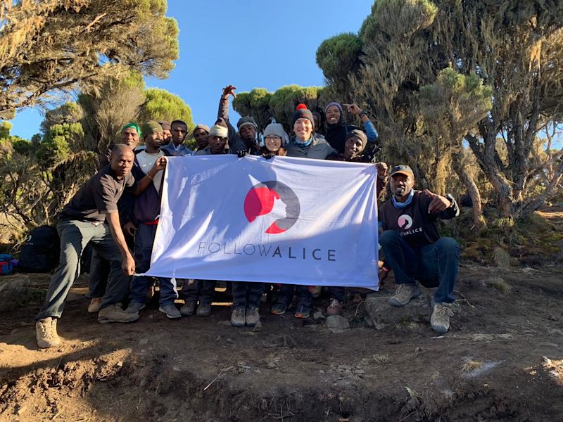 Group photo on Kilimanjaro with Follow Alice sign