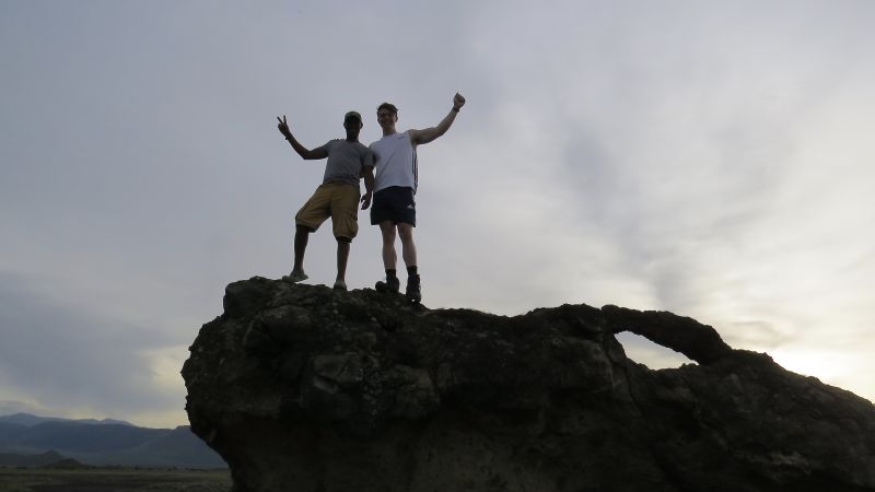 Two happy men standing on a rock near Lake Natron in Tanzania