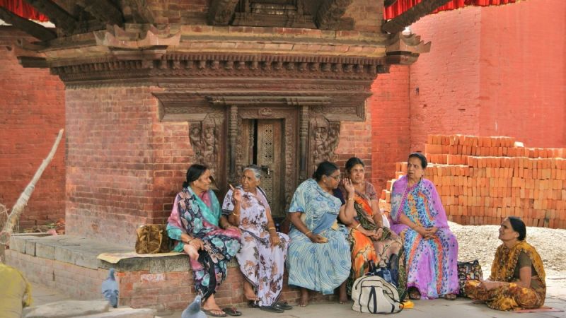 Women sit by a shrine in Kathmandu, Nepal