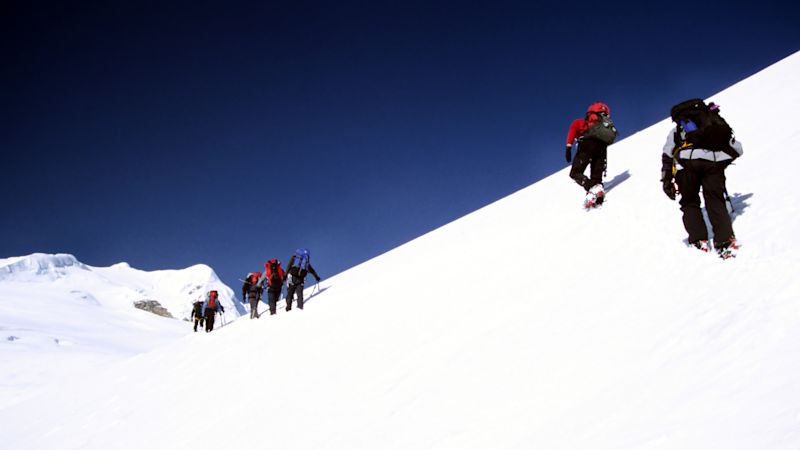 Climbing Mera Peak. Trekkers climbing from the Mera La, in the Himalayas on their way to summit Mera Peak