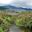 Low angle view of small wooden footbridge over stream in lush Landscape of mountain Phobjikha valley, Bhutan