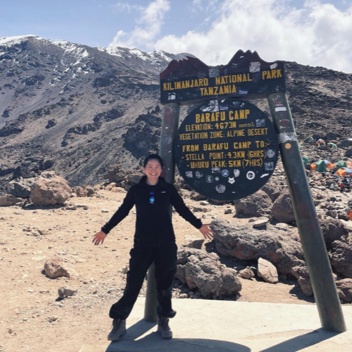 Woman standing next to Barafu Camp sign on Kilimanjaro, August 2022