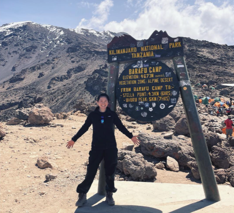 Woman standing next to Barafu Camp sign on Kilimanjaro, August 2022