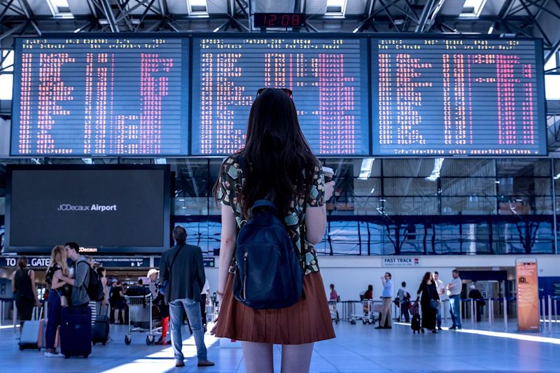 Young woman looking at flight monitor in airport