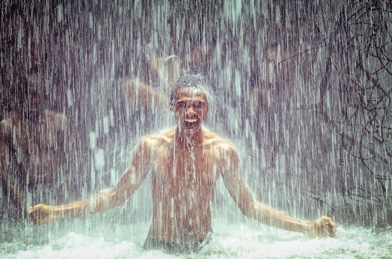 Man happy in waterfall