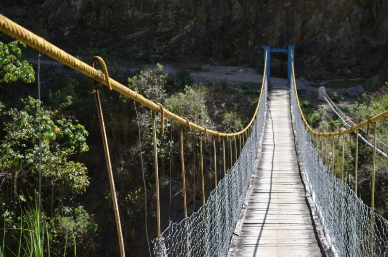 A hanging wire bridge spans the Urubamba river near Machu Picchu, Peru