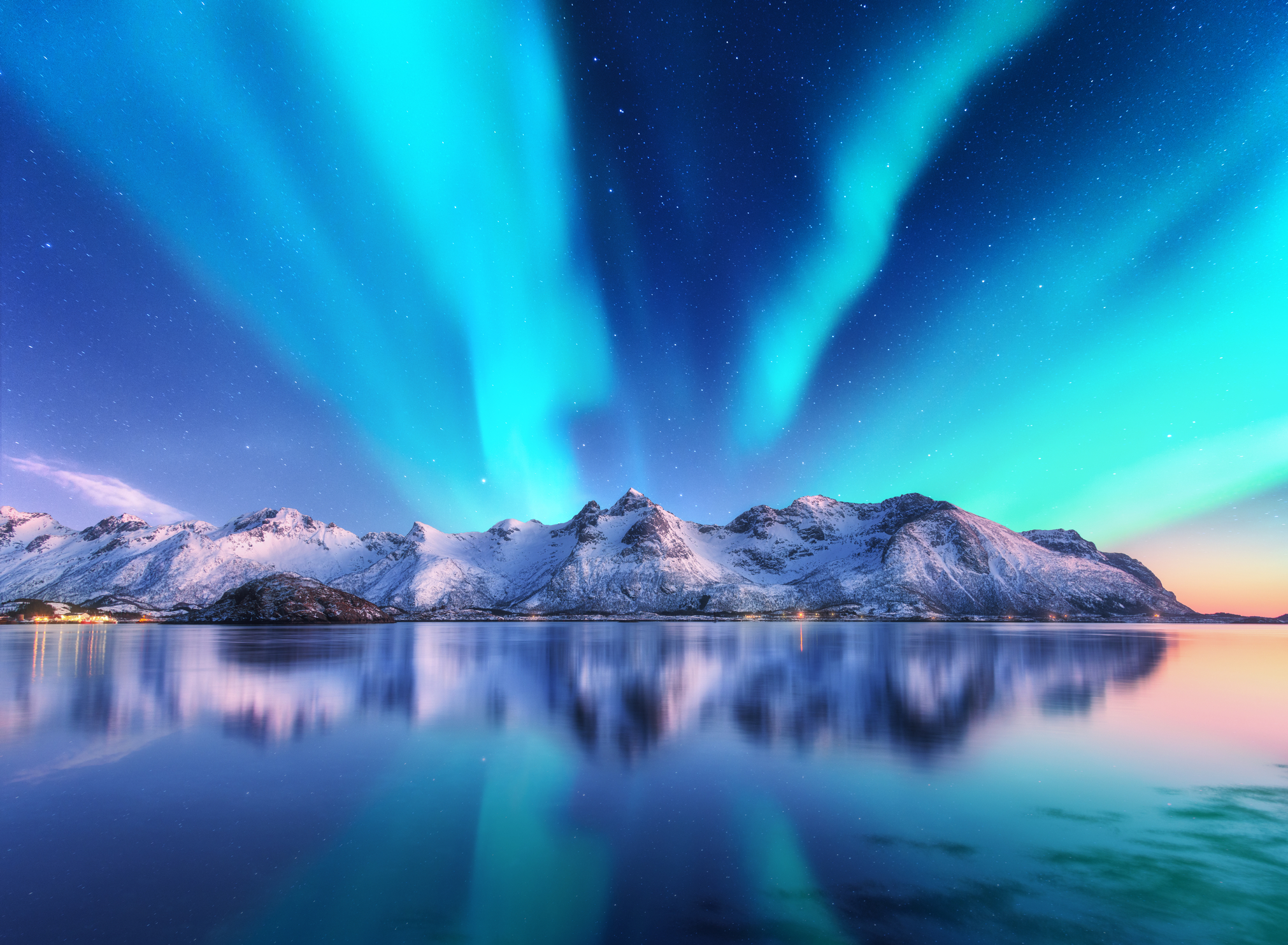 Northern lights and snow covered mountains in Lofoten islands, Norway.
