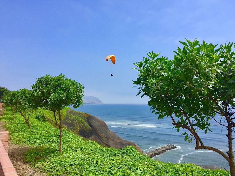 Paraglider over city of Lima and coastline, Peru