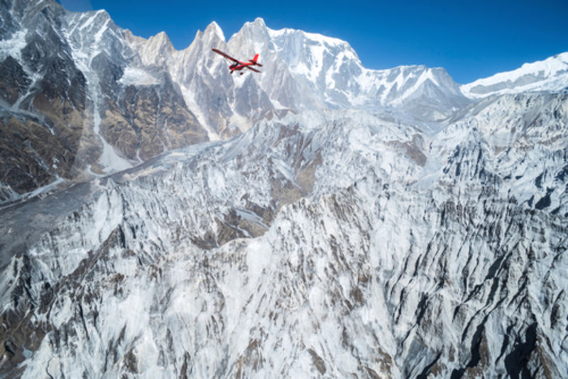Ultralight plane flies over Pokhara and Machapuchare in Annapurna region, Nepal