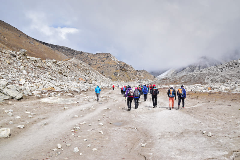Large trekking group walking on EBC trek up barren valley