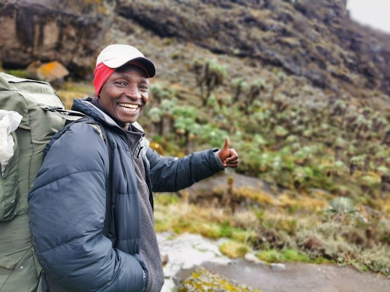 Florence-smiling-and-giving-thumbs-up-on-Kilimanjaro