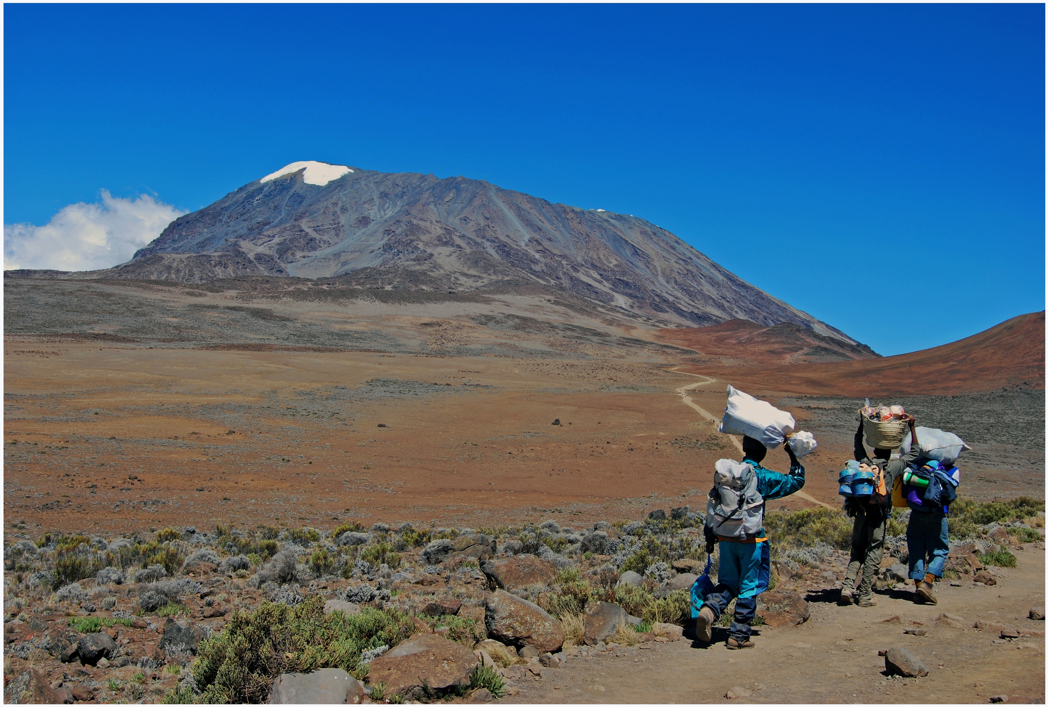 Porters on open path in alpine desert of Marangu route, Kilimanjaro