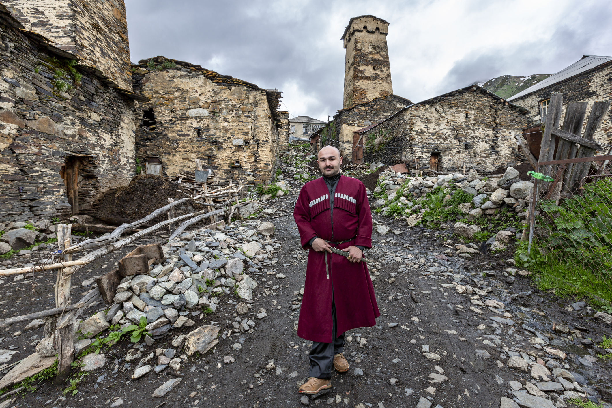 man in national costumes walking in the streets of the village Ushguli, Georgia
