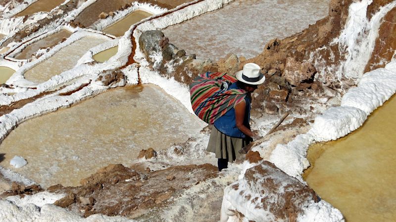 Quechua woman working in the Maras salt mines of Sacred Valley, Cusco, Peru