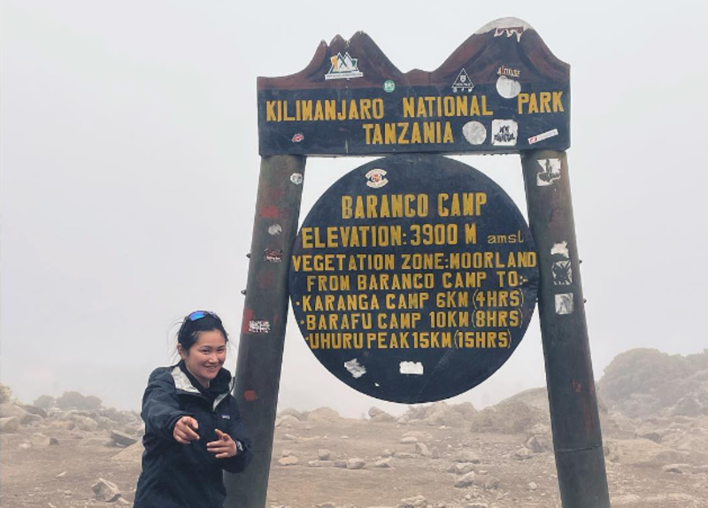Female hiker standing by sign for Barranco Camp on Kilimanjaro, August 2022
