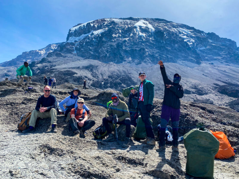 Group taking a rest stop on Kilimanjaro with Uhuru Peak behind