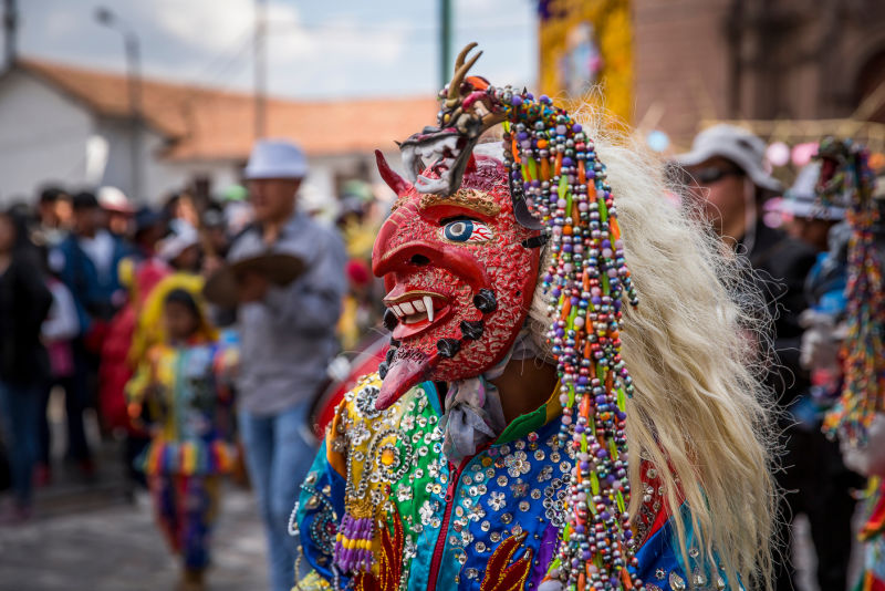 Dancer isolated with a devil mask in a religious parade in honor for the virgin of el carmen in Cusco Peru 