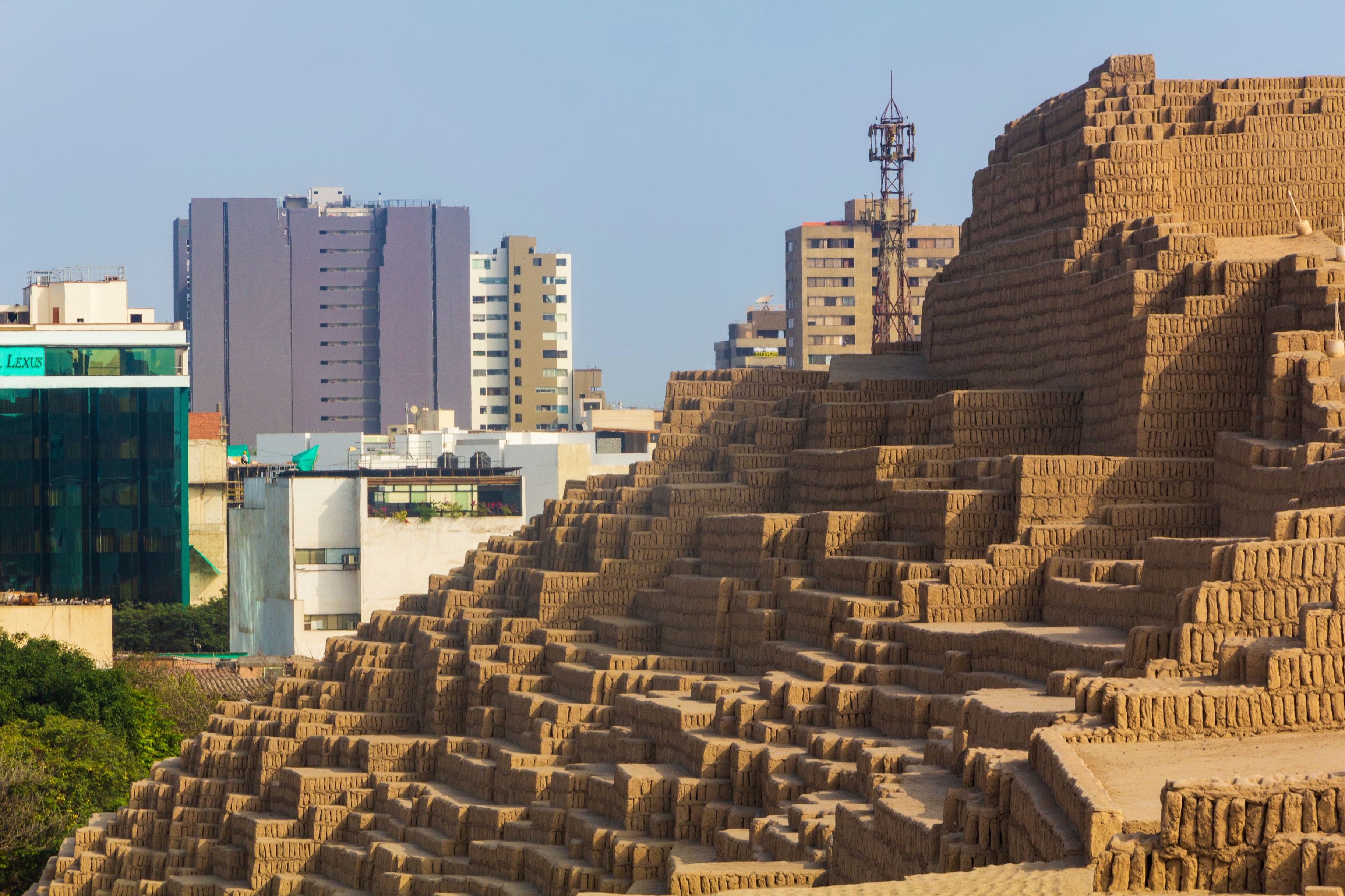 Ruins of the Huaca Pucllna Great Pyramid in Lima, with modern city buildings in background