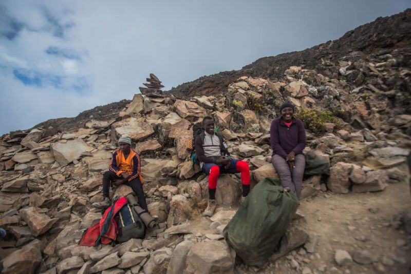 Follow Alice porters resting on the mountainside o fKilimanjaro