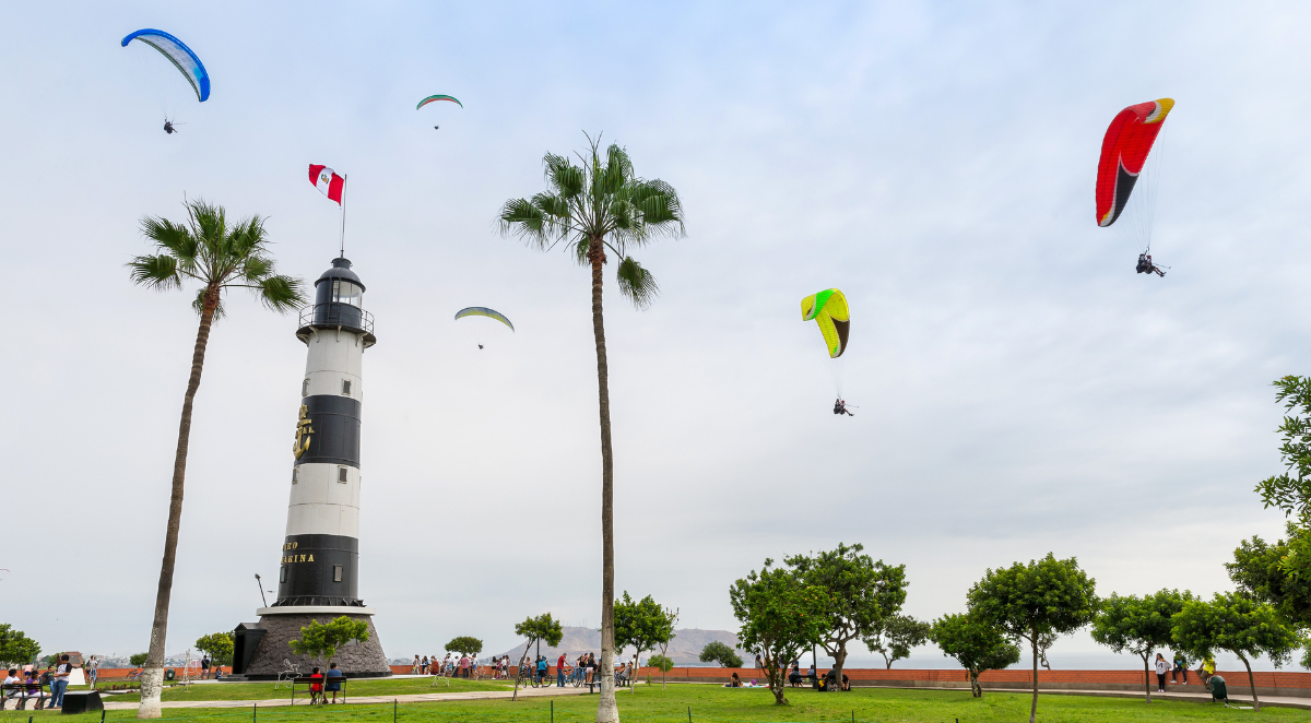 View of La Marina Lighthouse (Faro de La Marina) in Miraflores district, with some paragliders in the sky, in Lima Peru