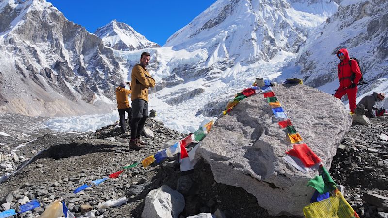 Everest Base Camp with flags and trekkers