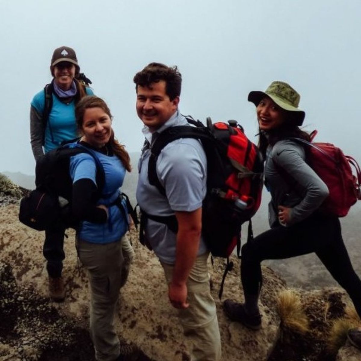 Four friends smiling with mist behind them on Kilimanjaro