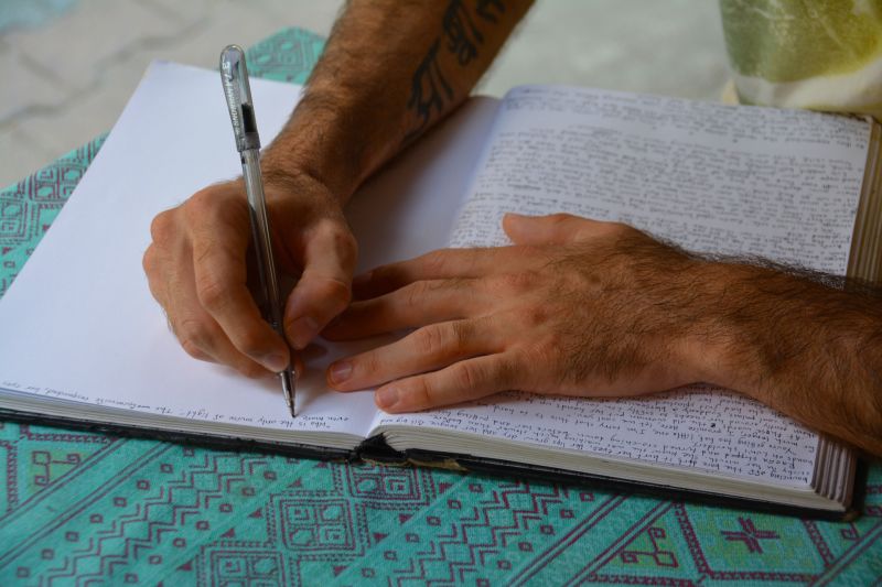 Man hands writing in a journal journalling diary