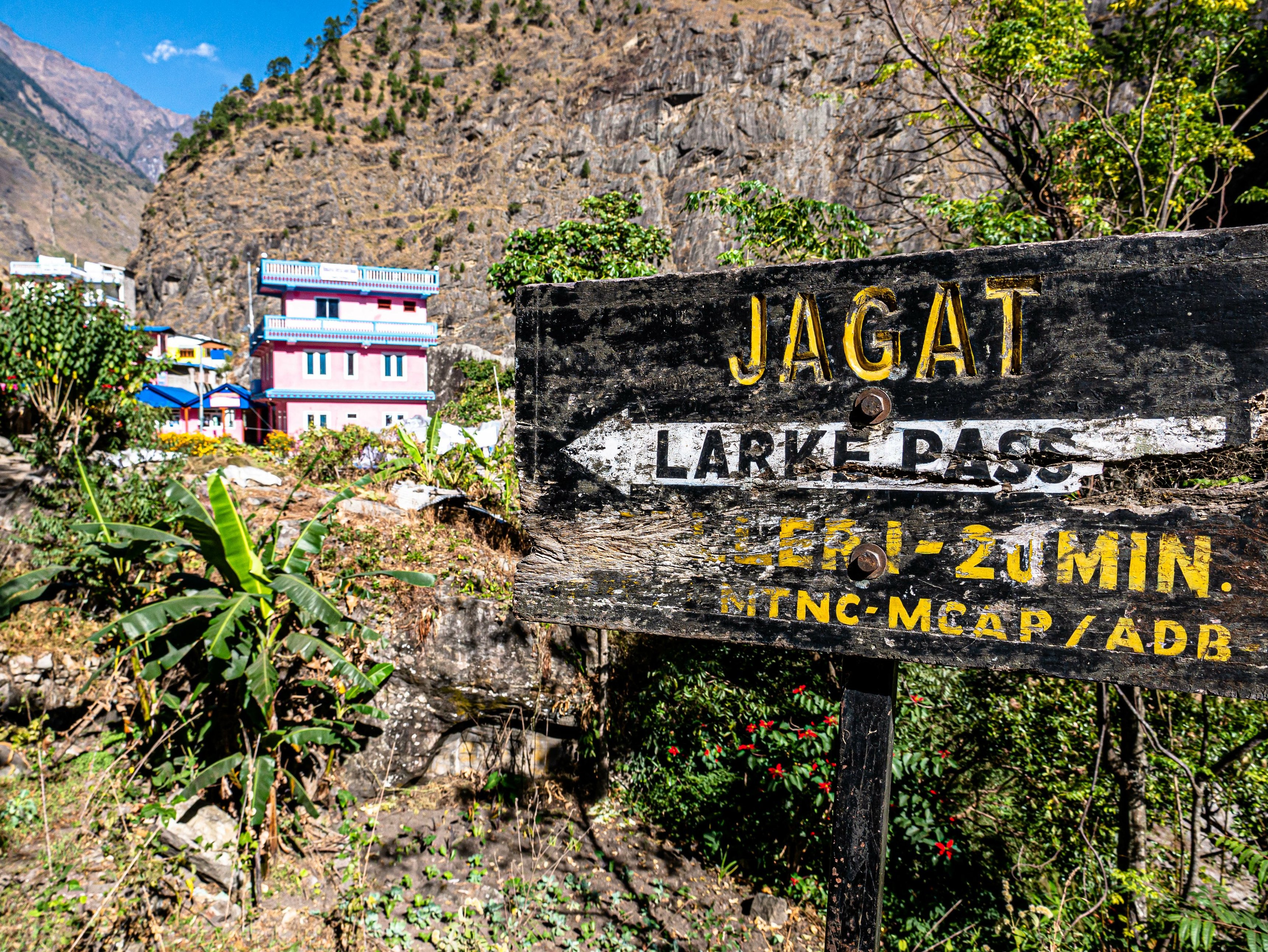 Signpost to Jagat village and Larkya Pass on the Manaslu Circuit trek in the Himalayas of Nepal
