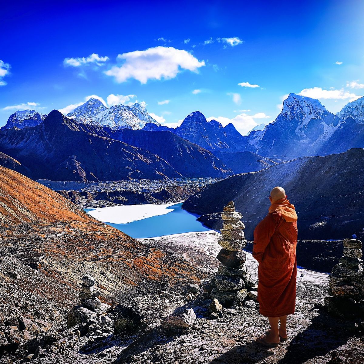 Buddhist monk in traditional red robe standing in Himalayas along Everest Base Camp trek route