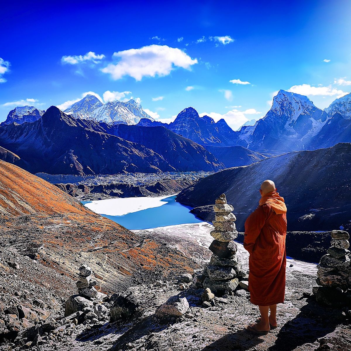 Buddhist monk in traditional red robe standing in Himalayas along Everest Base Camp trek route