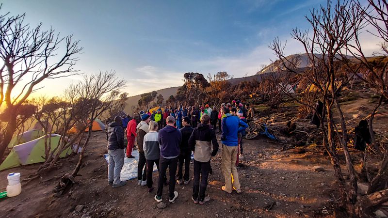 Kilimanjaro climb group in camp clothes and camp shoes / sneakers