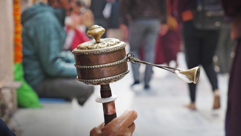 Hand-held Tibetan prayer wheel, street scene, Bhutan