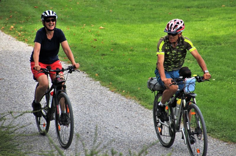 Two adults riding bicycles and smiling