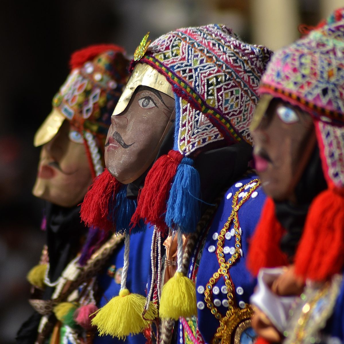 Performers in traditional Peruvian masks at a Cusco festival, Peru