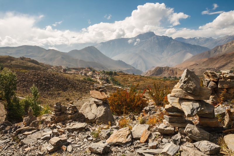 Himalayan landscape, cairns on background of mountain ranges and village of Ranipauwa. View from Muktinath Monastery, Lower Mustang, Nepal