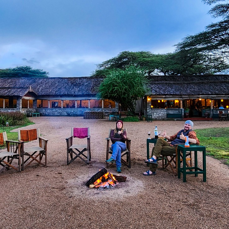 Tanzania Safari - Couple by lodge with campfire