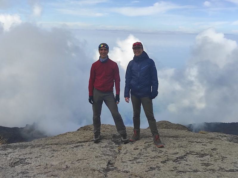 Two men standing on Kilimanjaro with clouds behind them