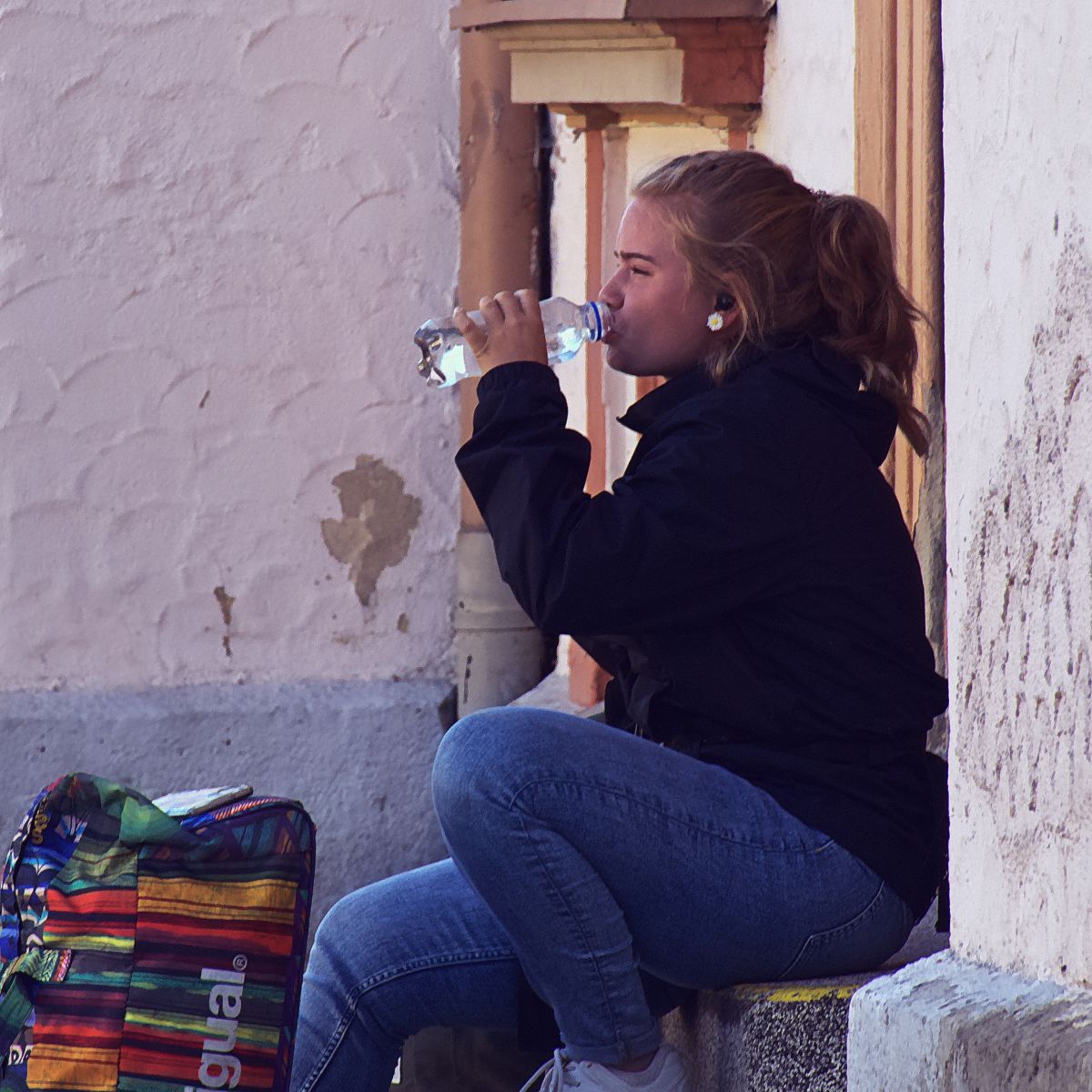 traveller-woman-drinking-water-on-stoop
