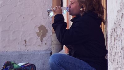 traveller-woman-drinking-water-on-stoop