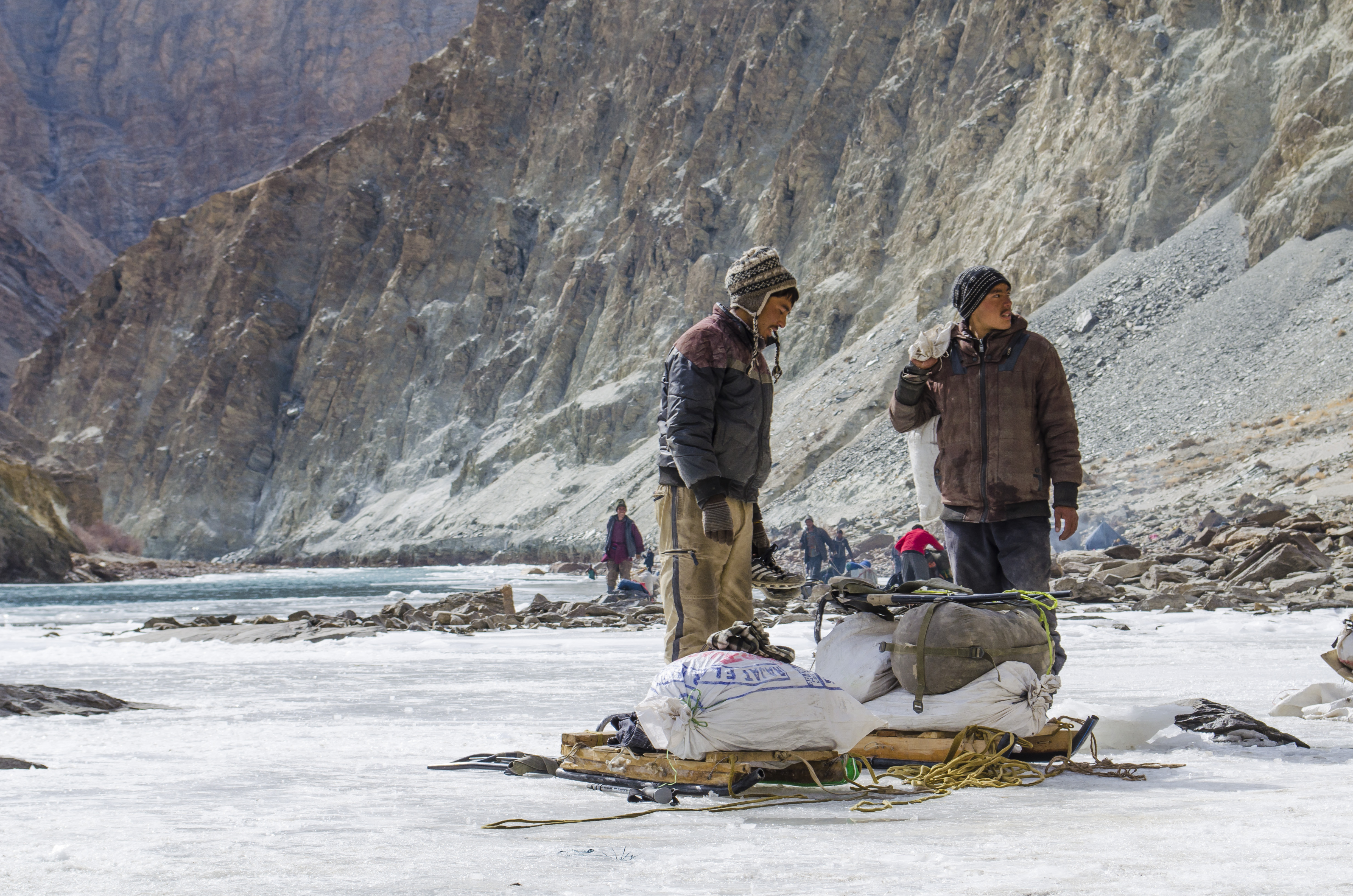 Local Sherpas carrying heavy loads over 40 kgs on the tricky terrain of the frozen Zanskar River.