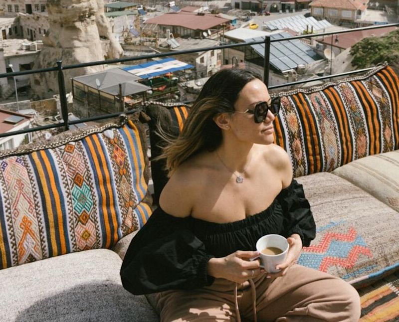 Woman sitting on a roof with a hot drink in Turkey