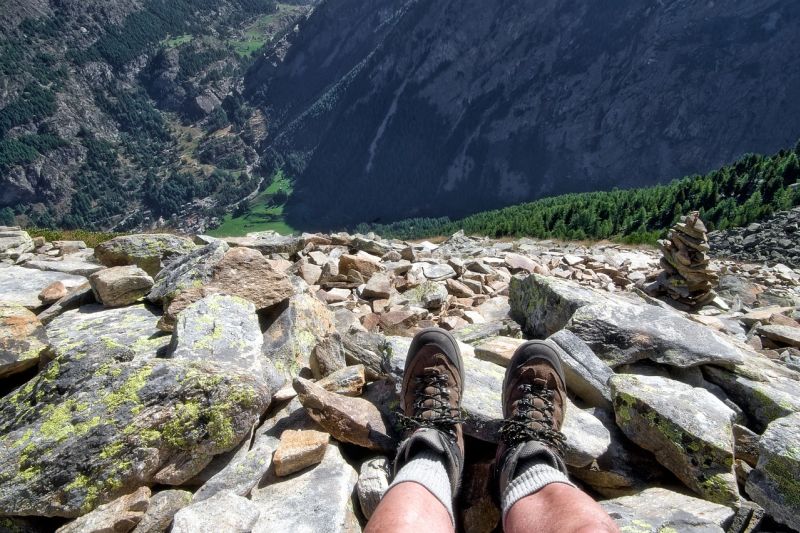Man's feet in hiking boots with mountain landscape in front